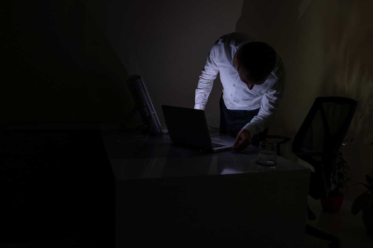Office worker preparing laptop after power cut