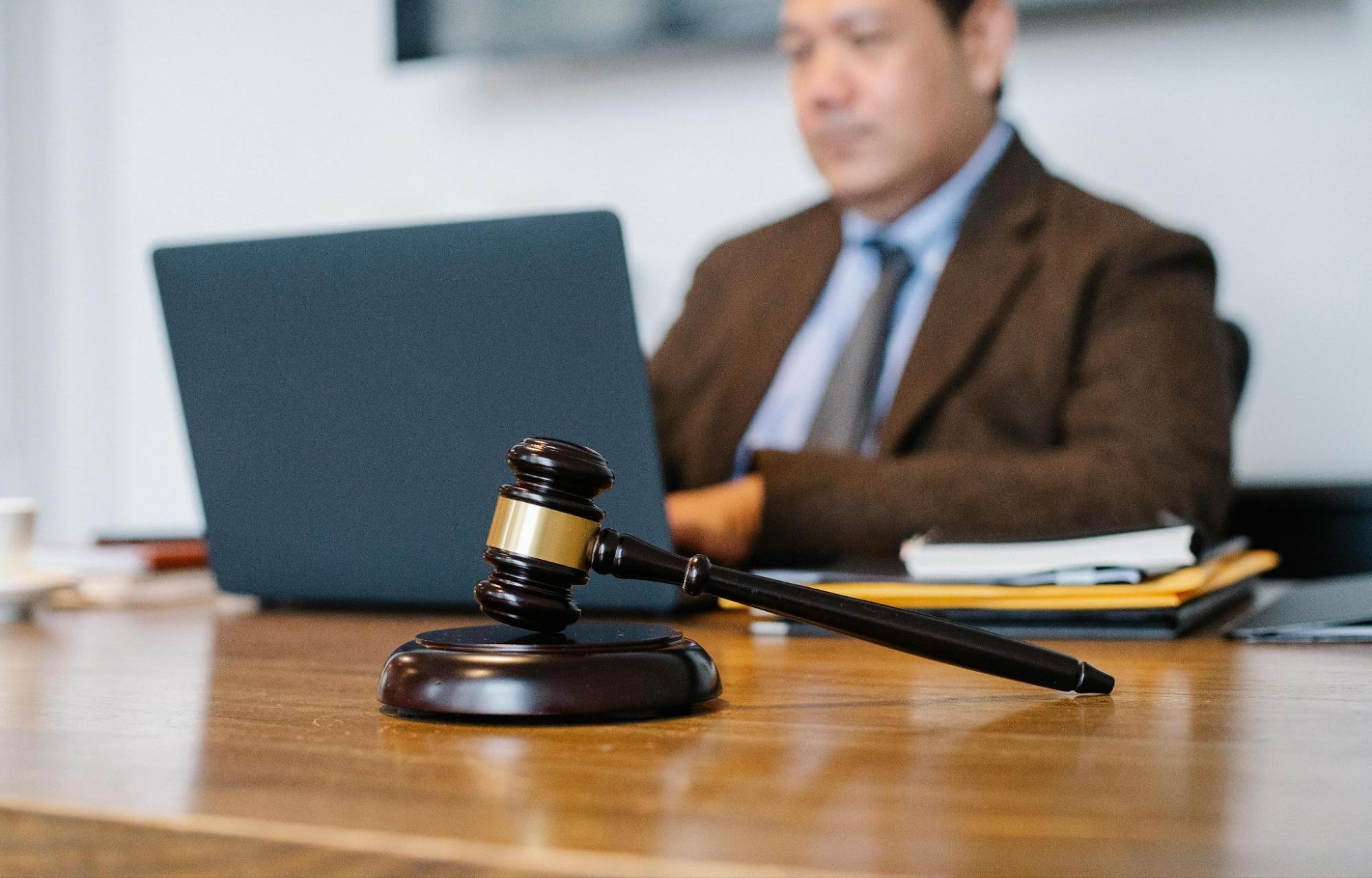judge working at his desk with a gavel in focus in front of him