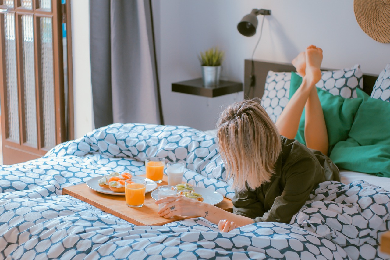 woman enjoying breakfast in bed woman lounging on bed with breakfast
