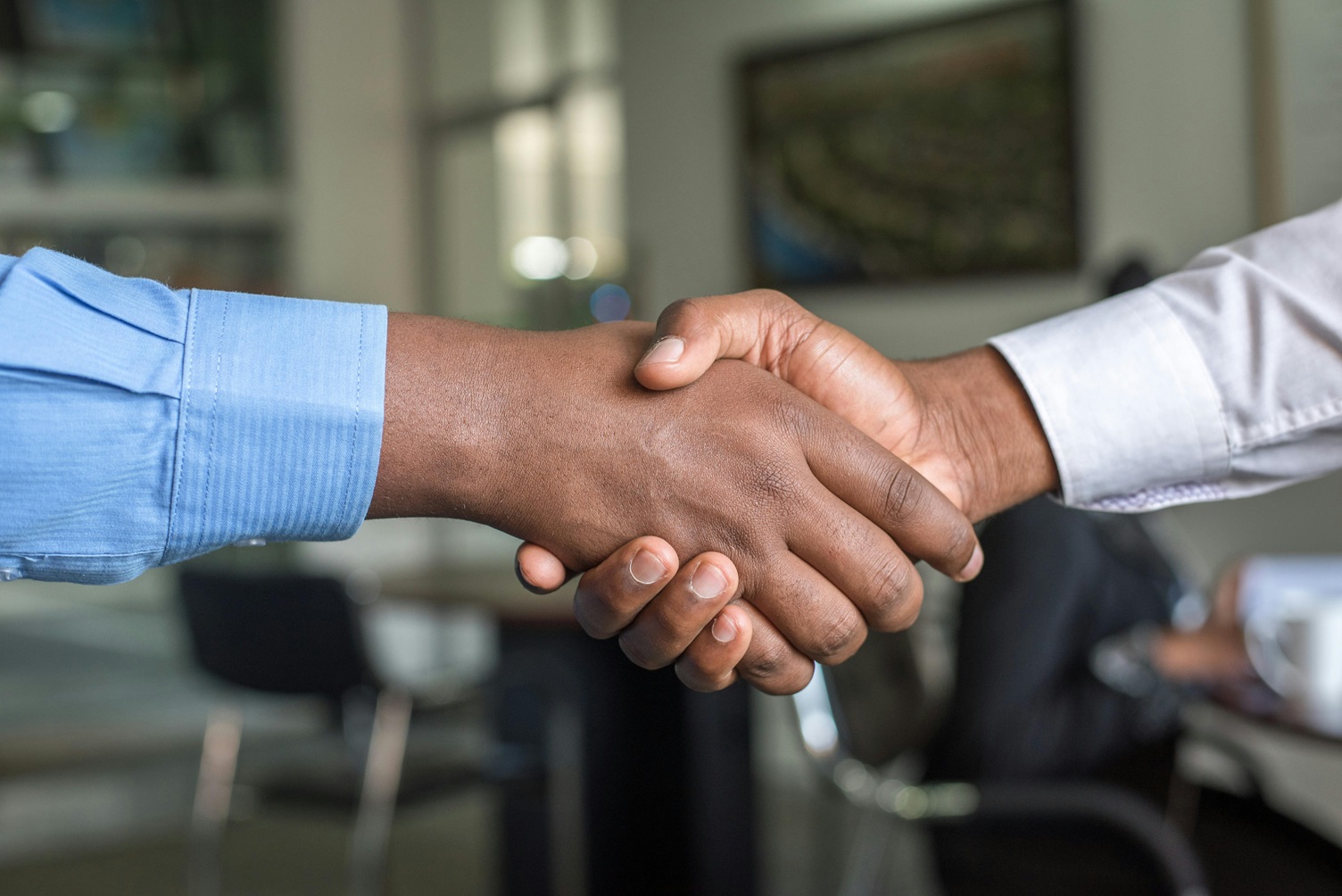 two men shaking hands after making a contract