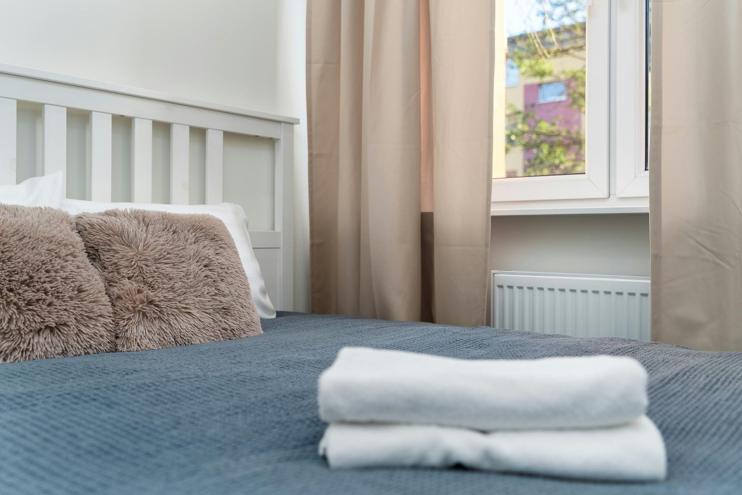 A neatly made bed with fresh linens and folded towels