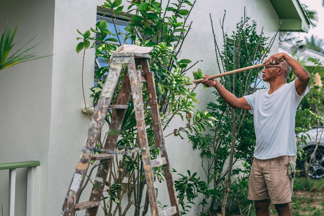 man painting exterior of house