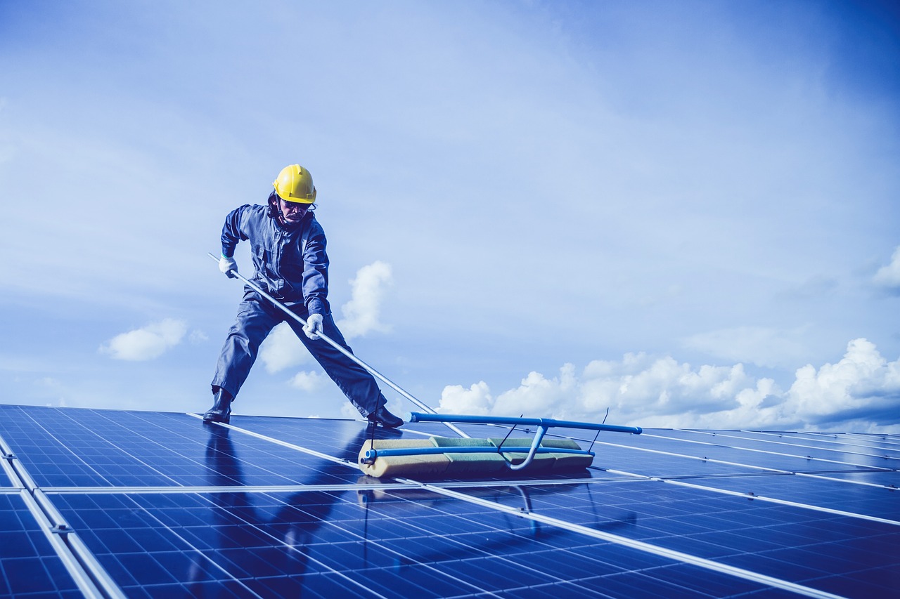 worker cleaning solar panels