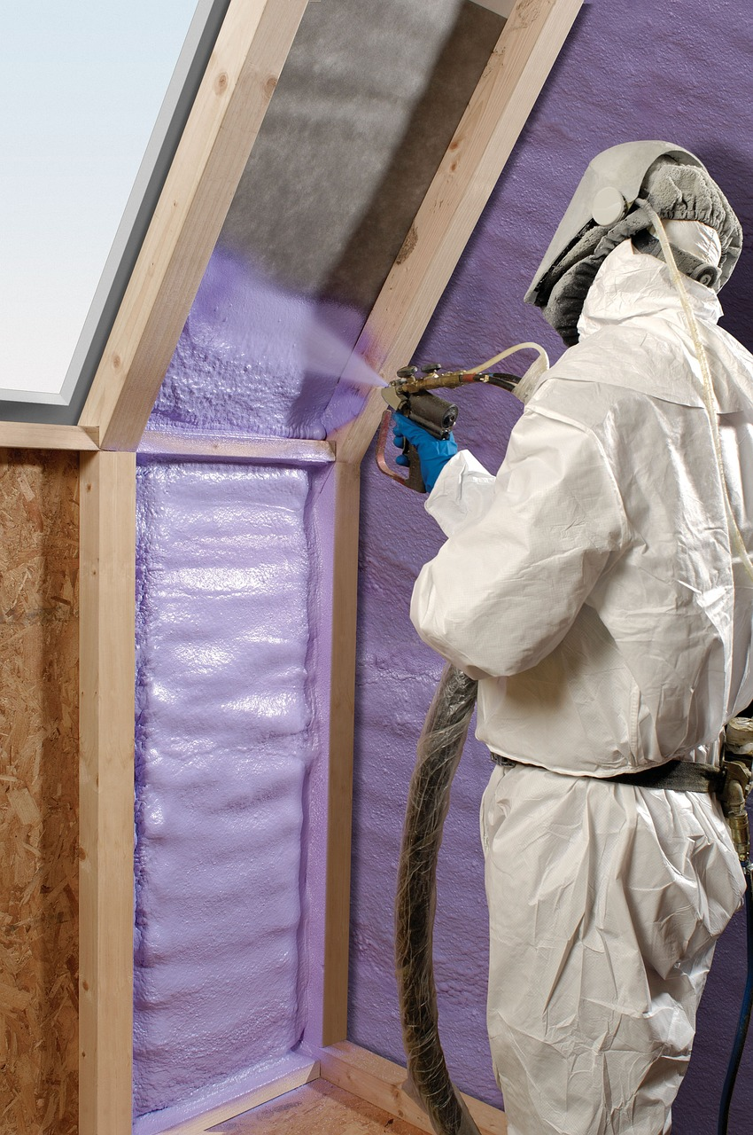 man in safety suit spraying foam insulation